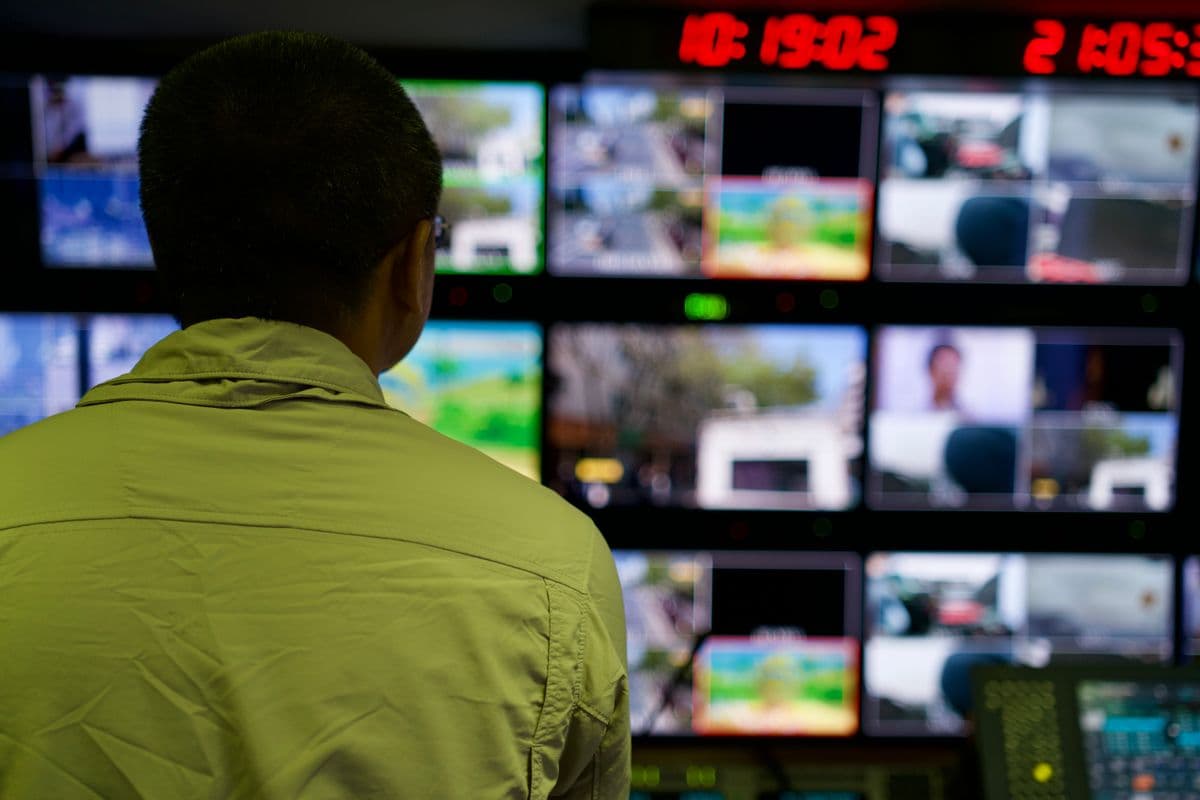 Operador supervisando múltiples monitores de un flujo de producción de video